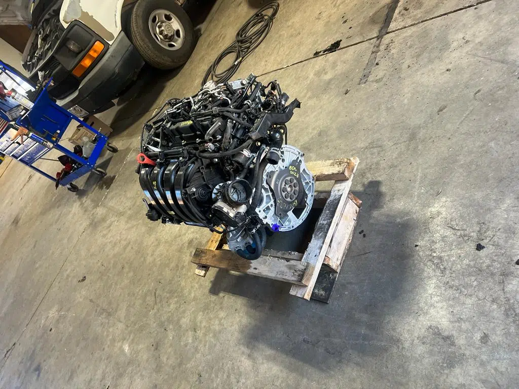 Removed engine sitting on a wooden pallet in the shop — PIQUET AUTO SERVICE in Greenville